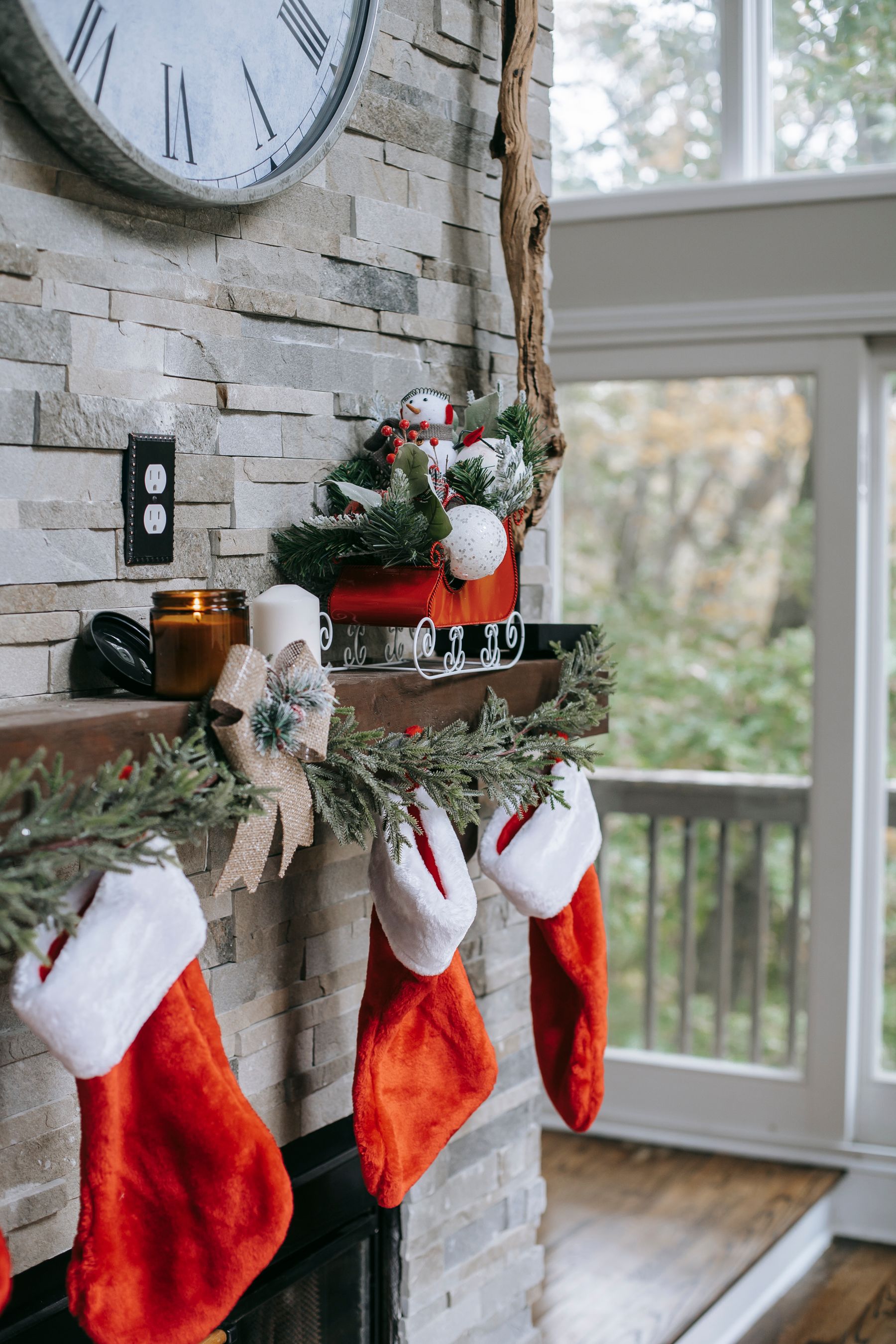 Evergreen garland with stockings on a brick mantel