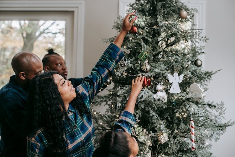 Positive Black Family Decorating Christmas Tree