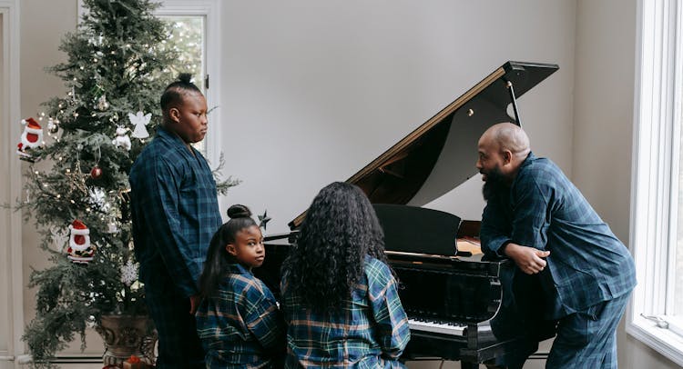 Black Family Playing Piano Together In Cozy Room