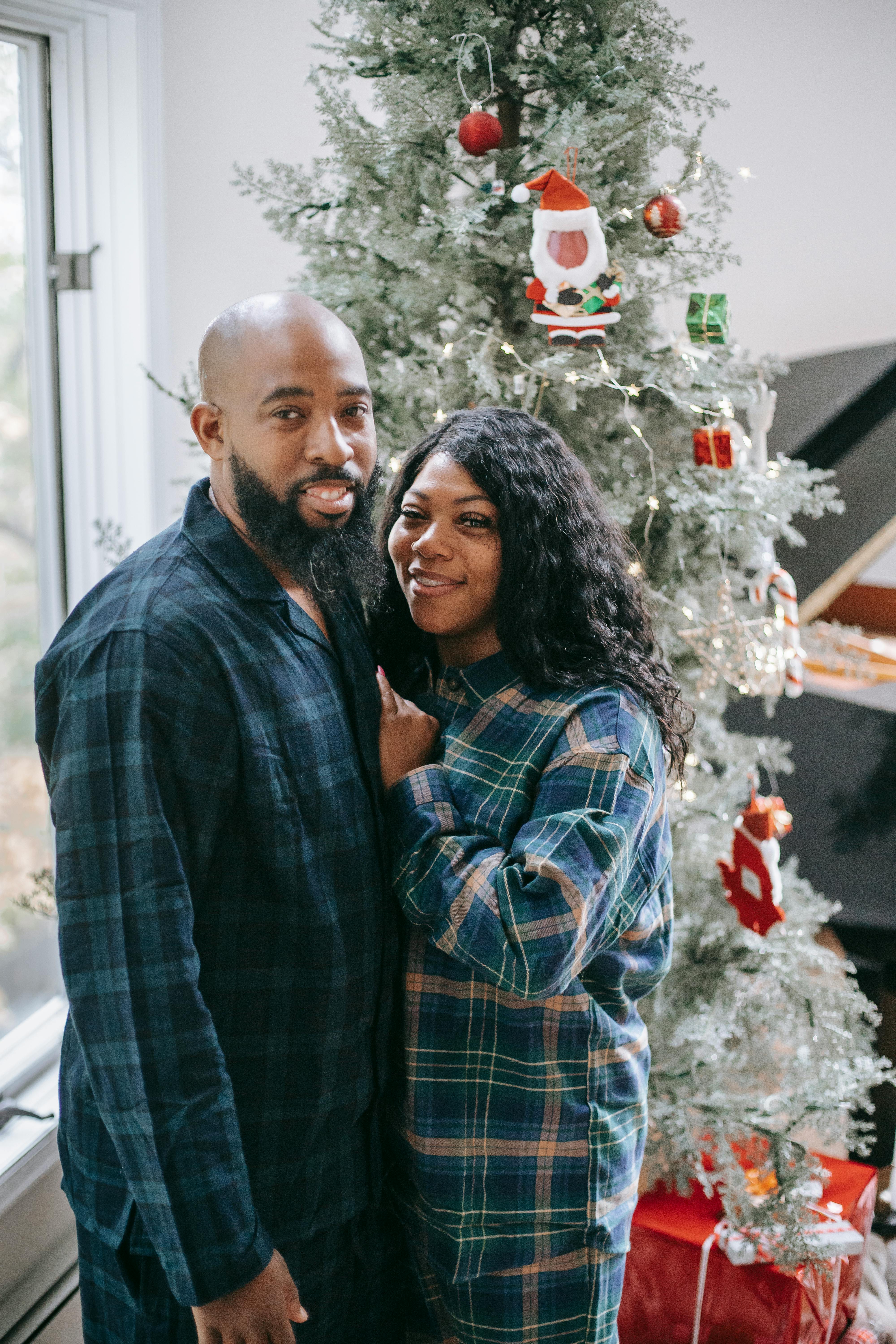 loving black couple embracing near fir tree