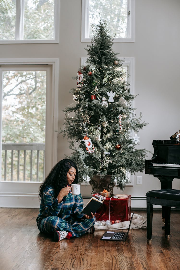 Calm Black Woman Drinking Coffee And Reading Book