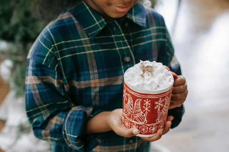 Black Child Holding Mug Of Hot Drink With Foam