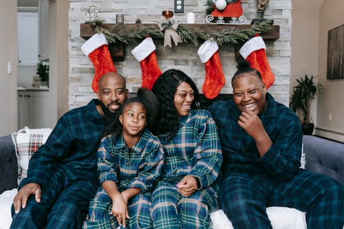 Free A Family Wearing Checkered Pajamas Sitting on a Couch Stock Photo