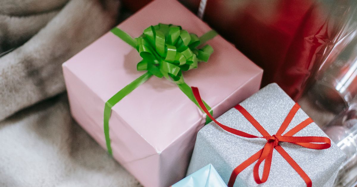 A group of people exchanging wrapped gifts during a festive holiday gathering with warm ambient lighting