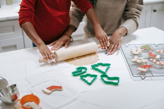 厨房里，父母正在准备姜饼饼干，而附近一个无法辨认民族的儿童正从面团中推出上面的作物