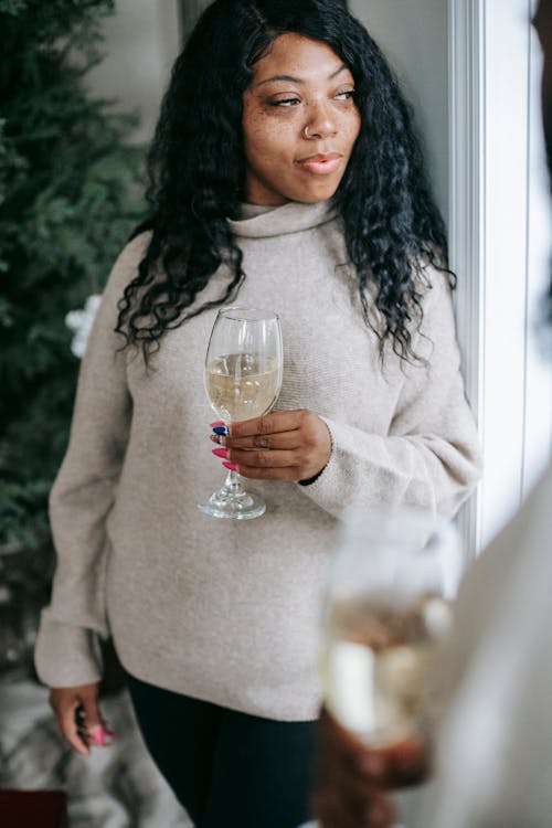 Crop black woman with glass of champagne near partner