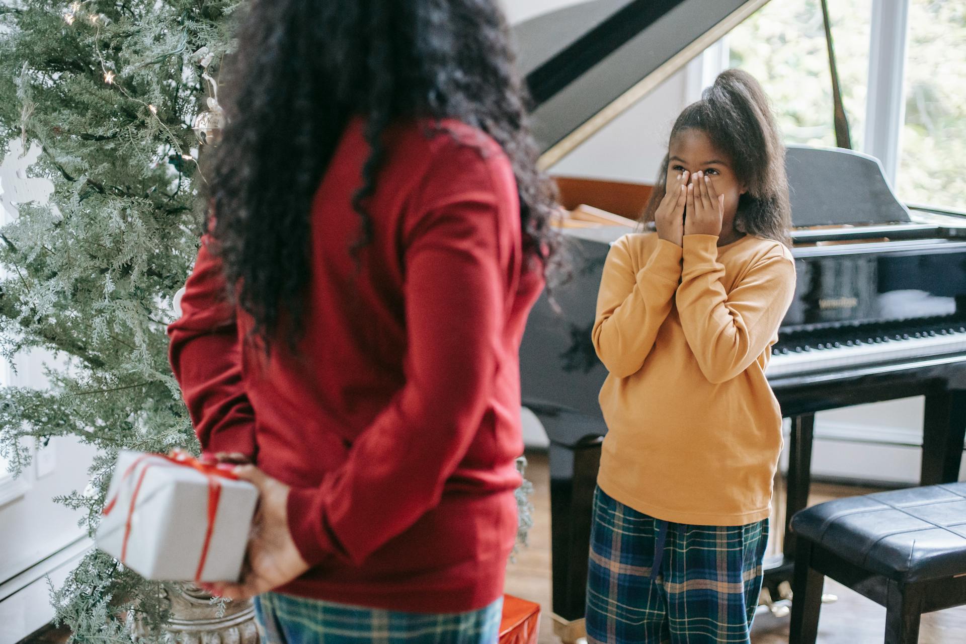 Photo of a Woman Giving a Kid a Gift