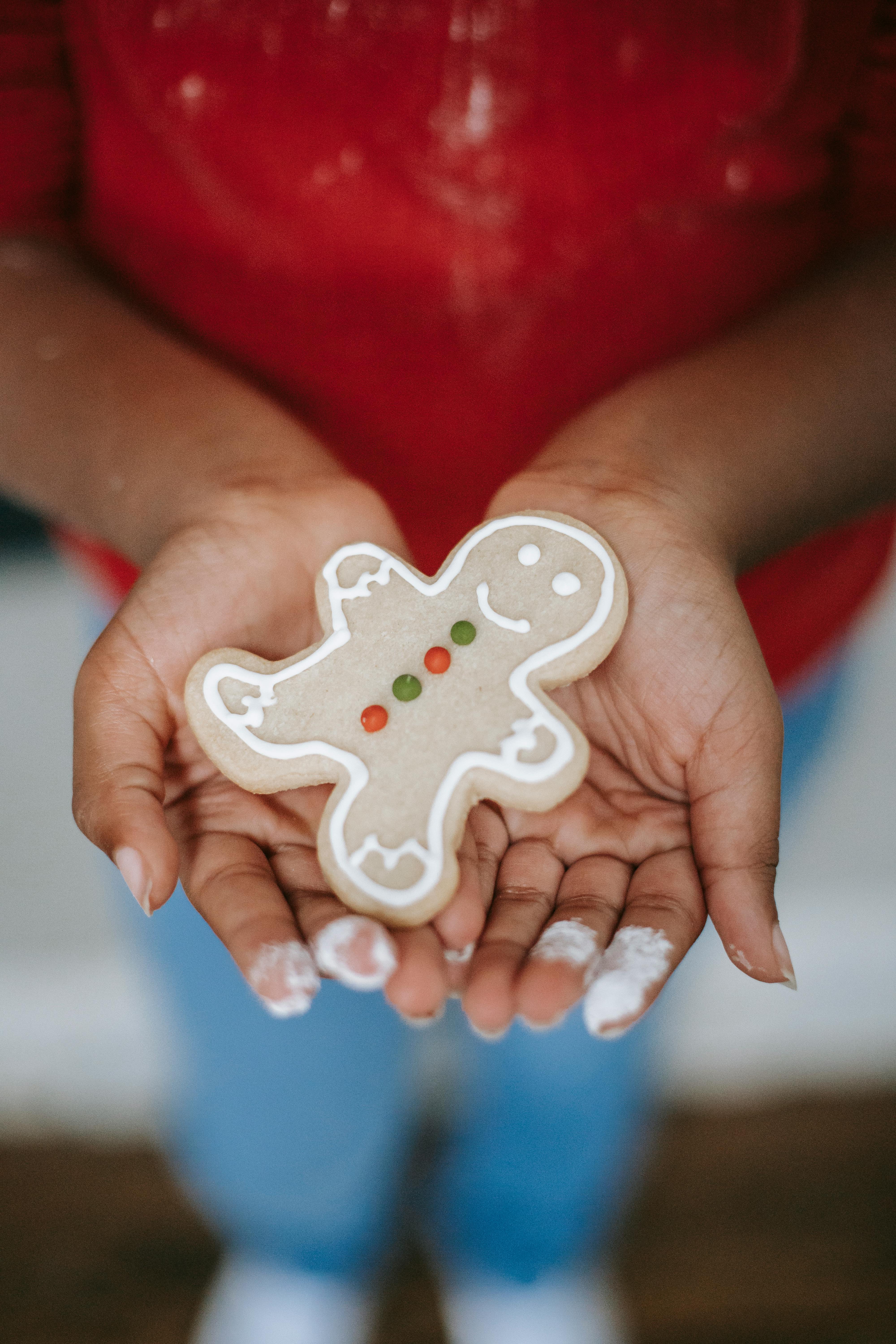 crop black child showing gingerbread cookie during christmas holiday