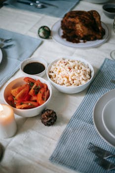 From above of appetizing pasta salad near sliced tomatoes and turkey on table during New Year holiday