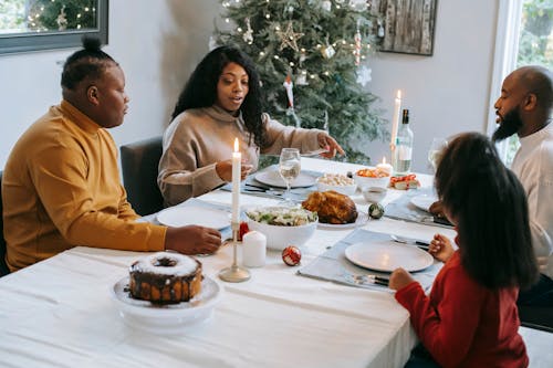 Black family dining at served table during Christmas holiday