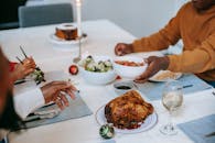 Crop black relatives at served table with Christmas meal