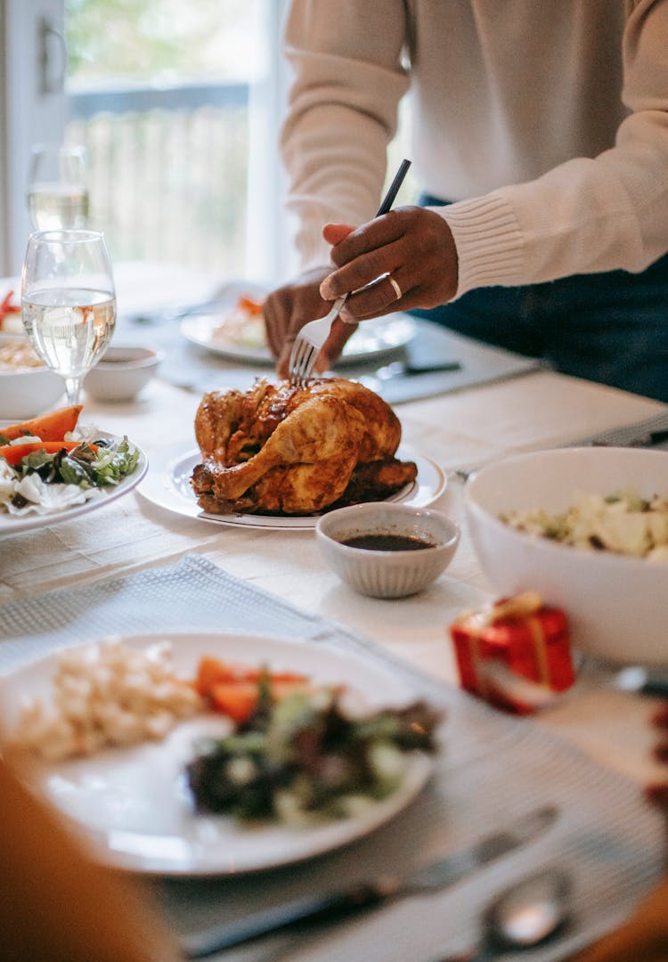 Crop Black Man Cutting Chicken