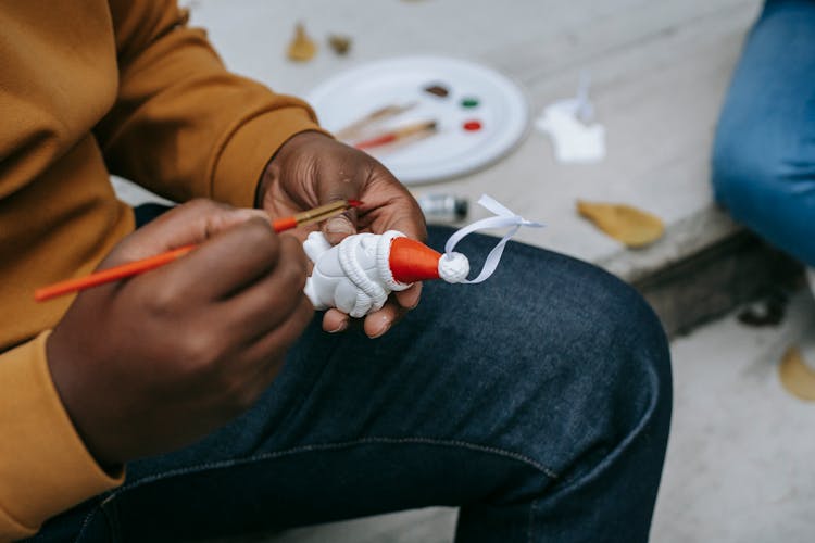 Crop Black Man Painting On Toy