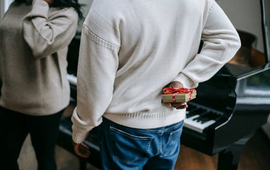 An intimate moment of gift-giving during the holiday season by the piano. by Any Lane