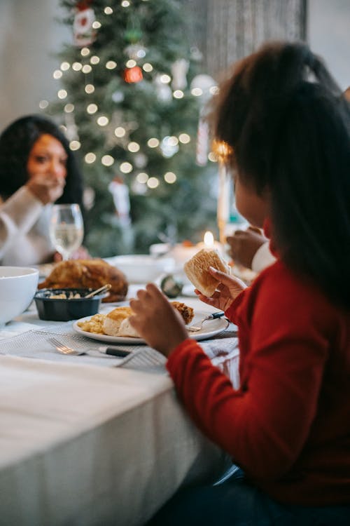 Free Black girl having dinner at table Stock Photo