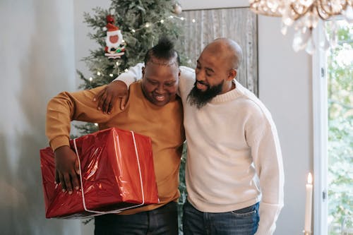 Cheerful black father hugging son