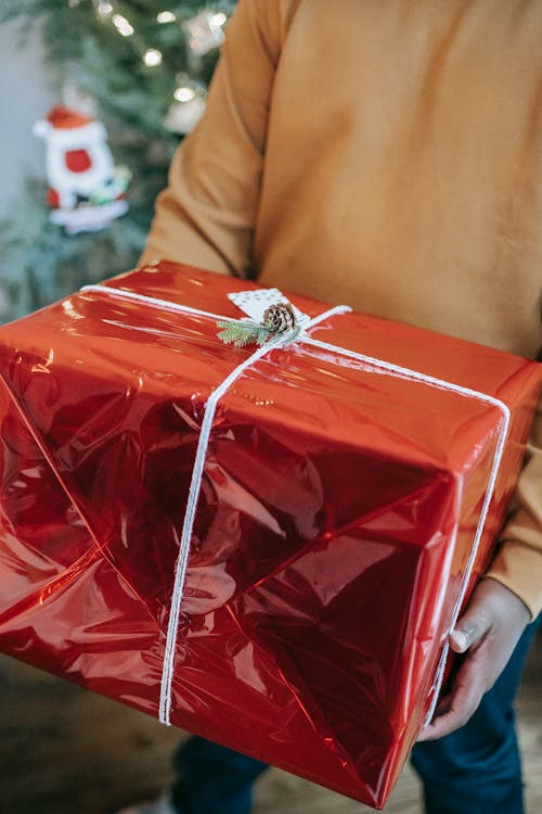 黑人攜帶有禮物的明亮的紅色箱子在發光的包裹