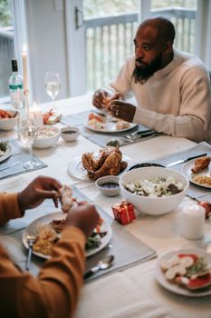 Enjoying a warm, intimate family meal with roast chicken and sides.