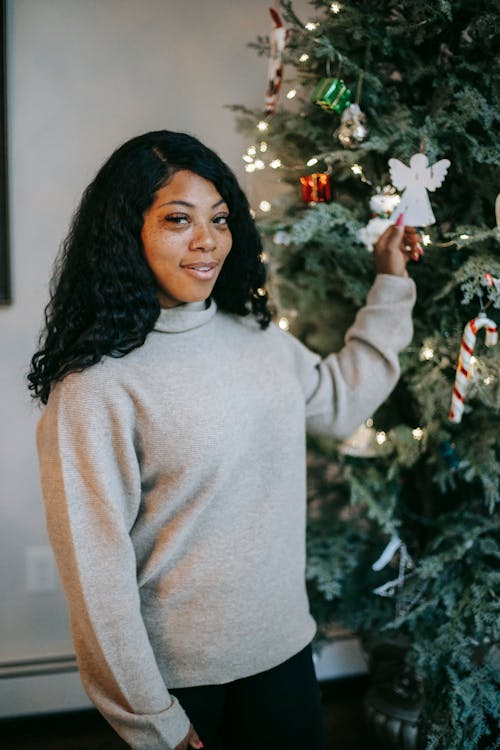 Black woman near decorated Christmas tree