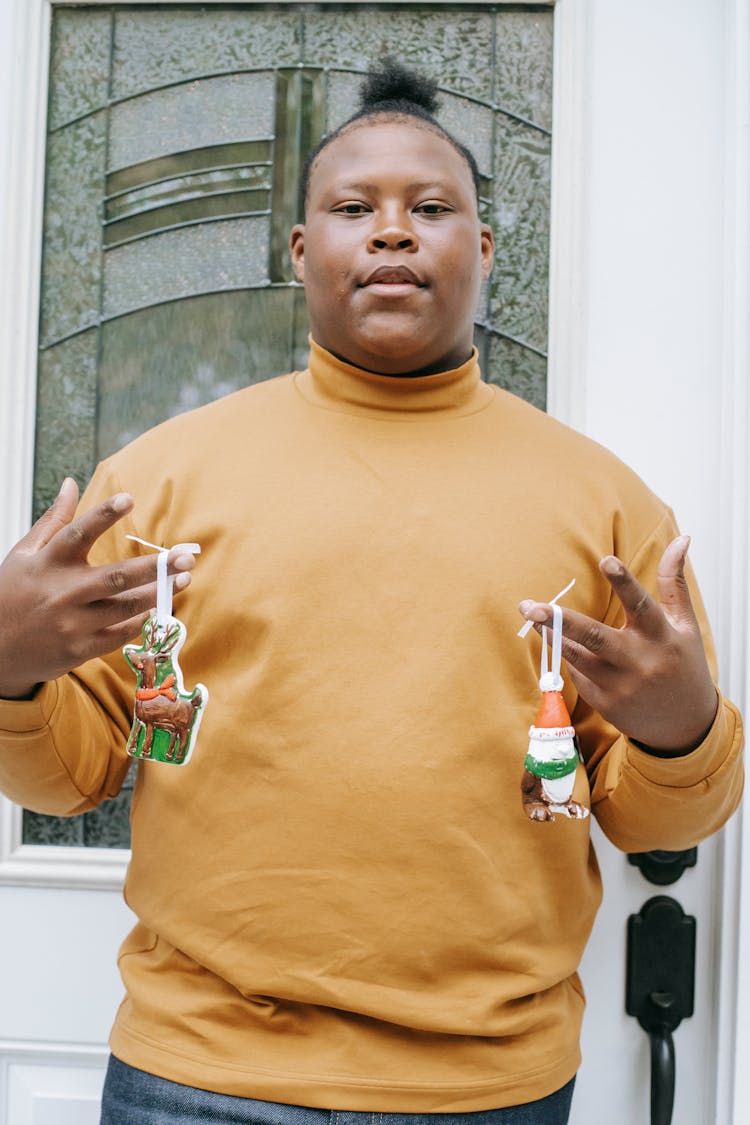 Black Teenager With Christmas Decorations At House Entrance