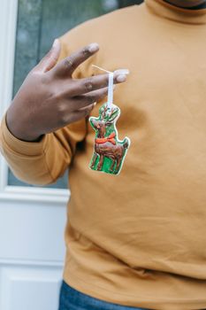 特写镜头中，一个人手持彩色驯鹿装饰品，非常适合节日装饰