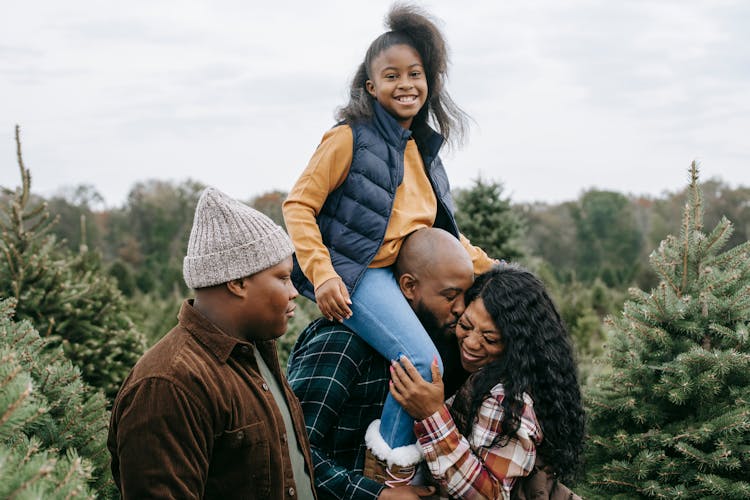 Cheerful Black Family Having Fun Together Among Spruce