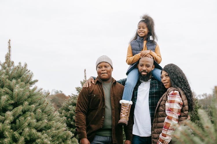 Cheerful Black Family Choosing Fir Tree Together