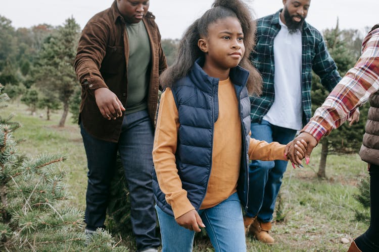 Black Family Carrying Fir Tree For Christmas