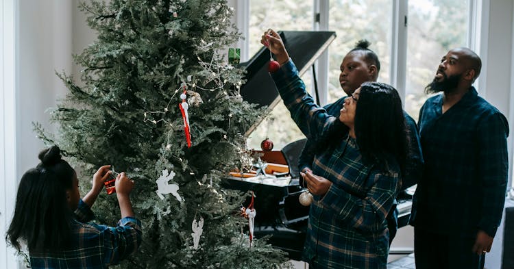 Black Family Decorating Xmas Tree With Toys