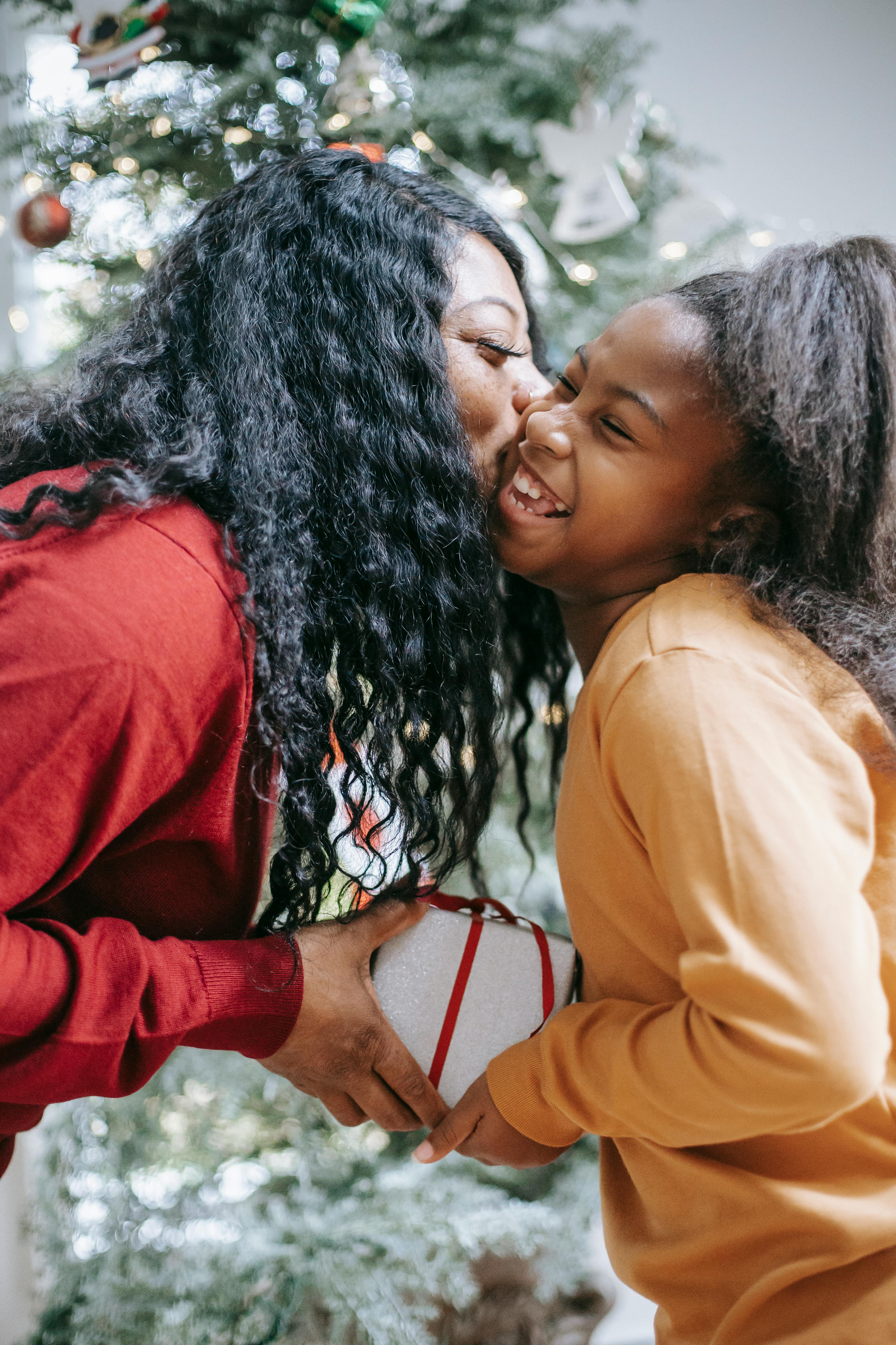 happy black mother giving present to daughter