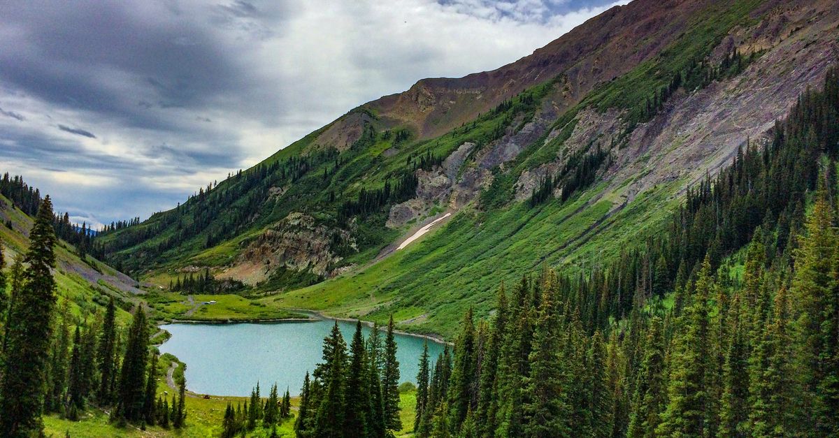Breathtaking mountain landscape with lush greenery and a shimmering lake in Aspen, Colorado.