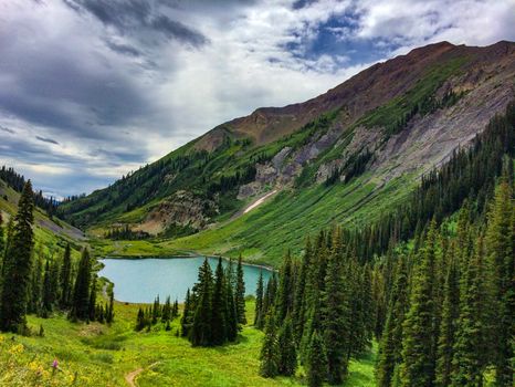 Breathtaking mountain landscape with lush greenery and a shimmering lake in Aspen, Colorado.