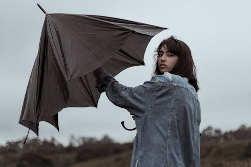 Young woman opening umbrella in overcast day