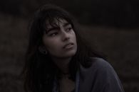 黄昏时分，一位沉思的年轻女子凝望远方，流露出宁静的心绪