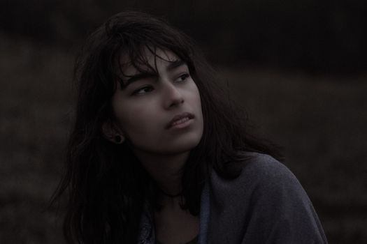 黄昏时分，一位沉思的年轻女子凝望远方，流露出宁静的心绪