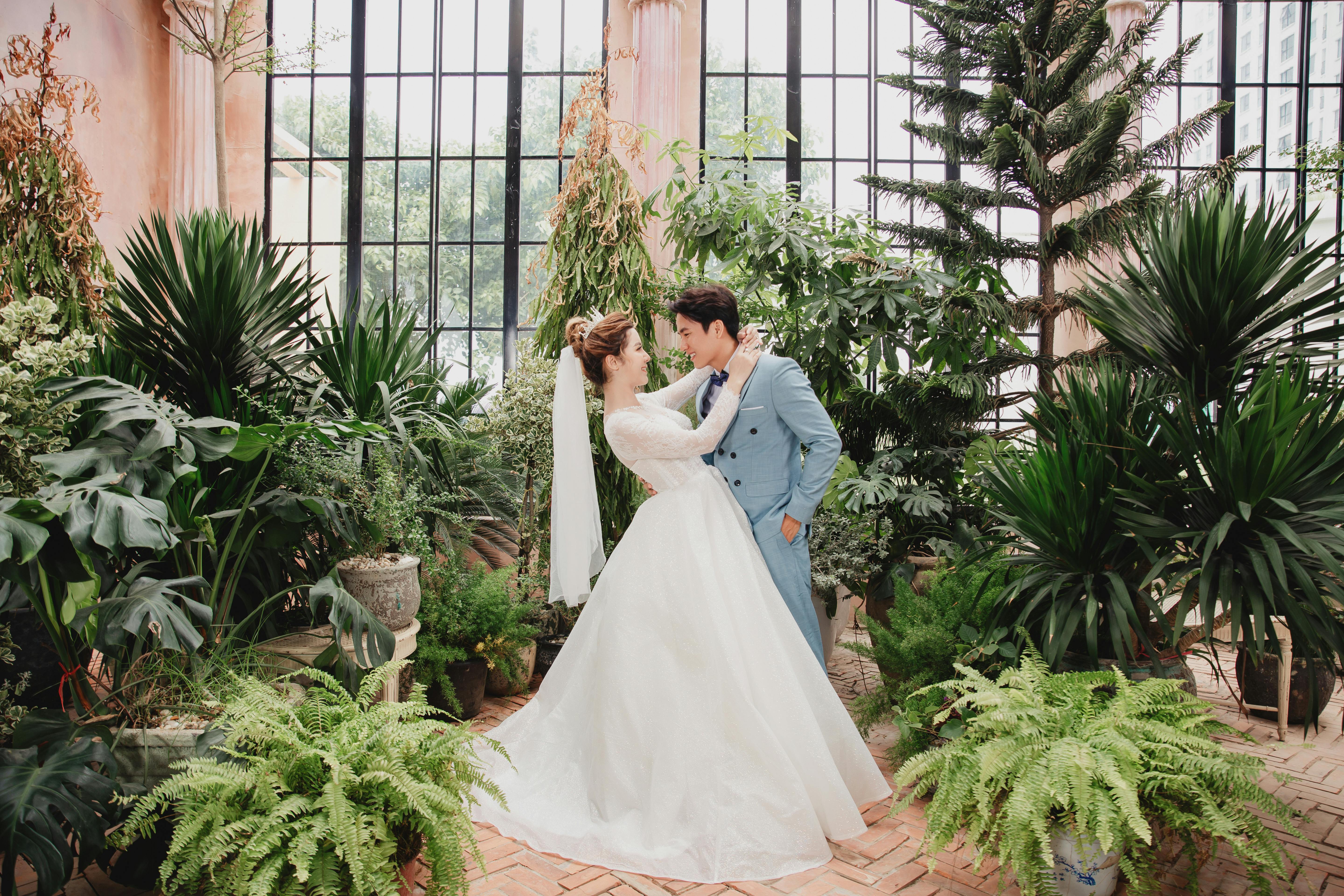 happy asian newlyweds bonding in indoor garden