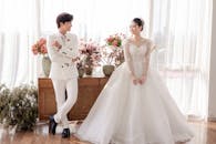 Smiling newlywed Asian couple in light room