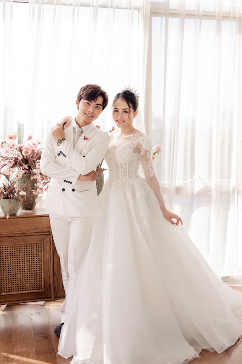 Free Cheerful Asian newlyweds standing in stylish studio Stock Photo