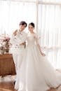 Cheerful Asian newlyweds standing in stylish studio