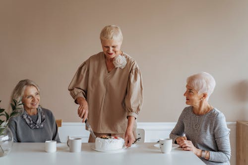 Elderly Woman Cutting Birthday Cake