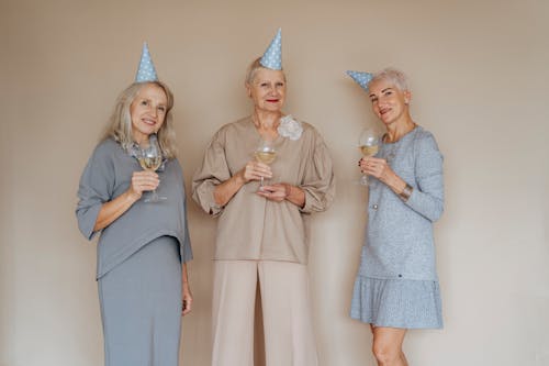 Photo of Elderly Women with Party Hats Holding Glasses