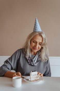 老妇人在生日庆祝活动中享用了一块蛋糕