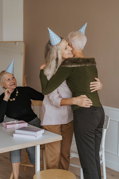 Photo of an Elderly Woman Hugging Her Friend