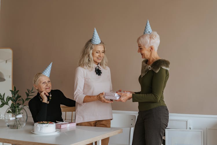 Elderly Woman In A Green Top Giving Gifts