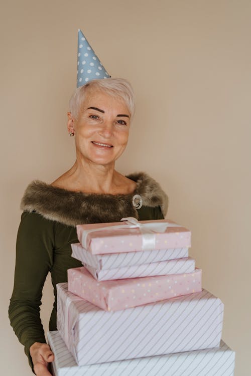 Free A Woman Holding a Stack of Gifts  Stock Photo