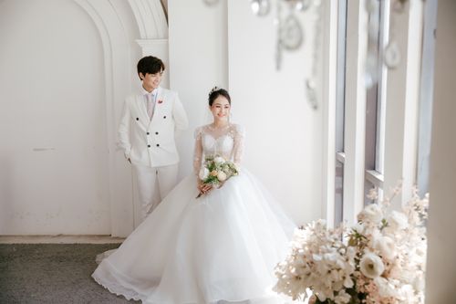 Free Full body of cheerful ethnic bride with bunch of fresh flowers near positive groom Stock Photo