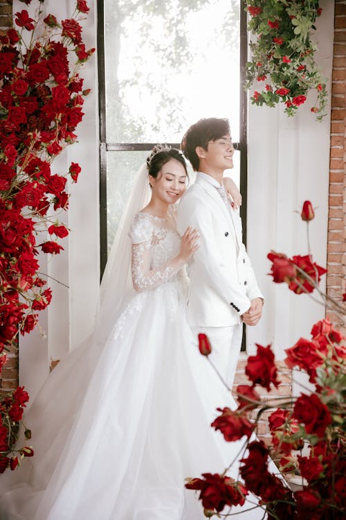 Loving Asian bride embracing smiling groom