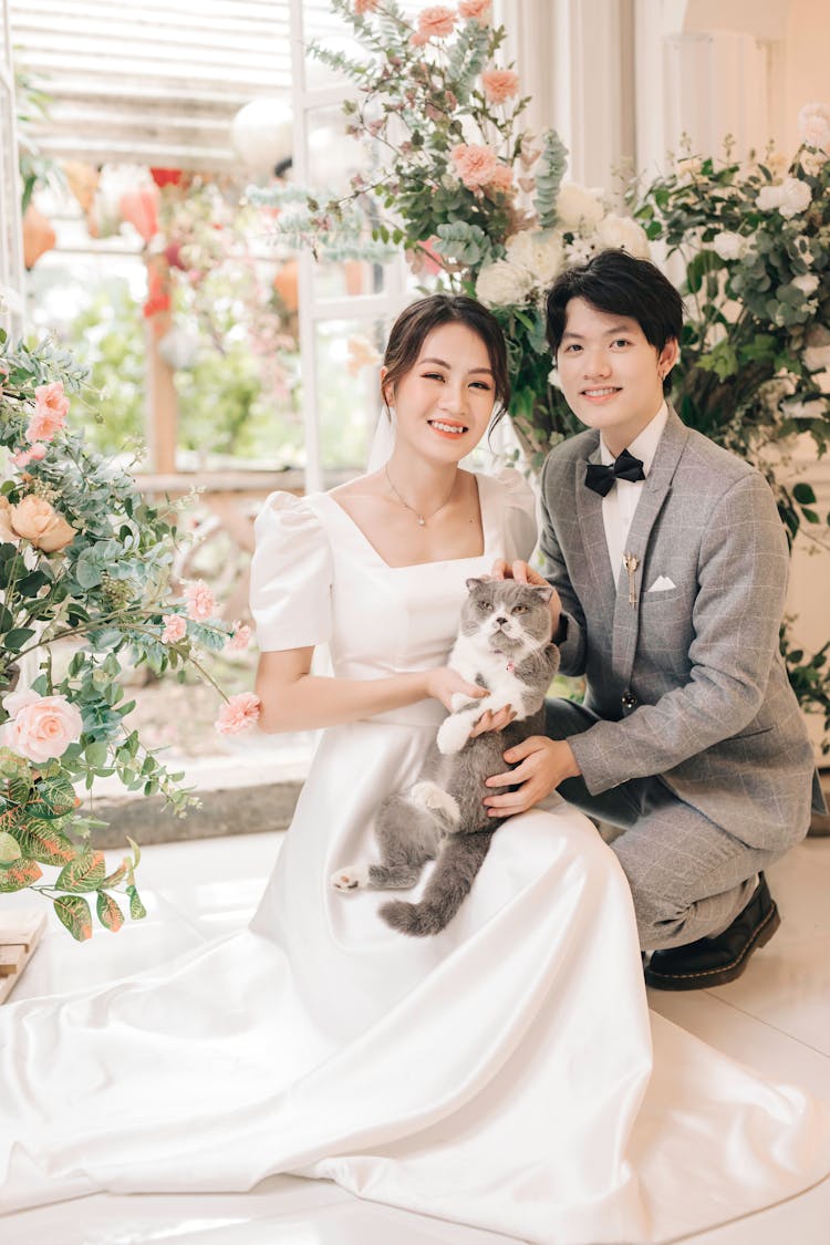 Portrait Of Happy Bride And Groom With Cat