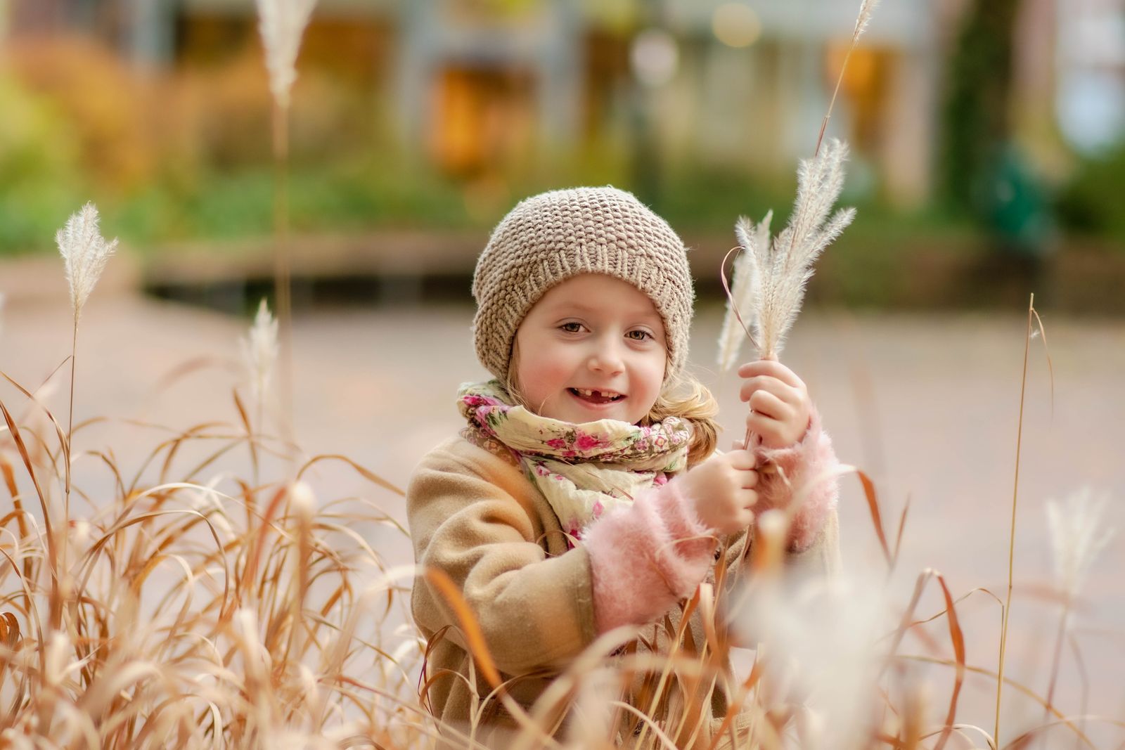 Child in a knit hat in tall autumn grass &mdash; photo by Andrey Dvoretskiy on Pexels