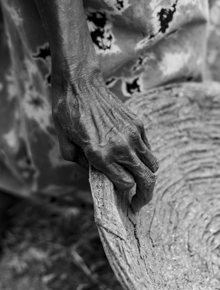 Close-up Of Old Person Hand Holding Wooden Plate